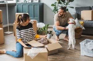 Young couple moving in new house. They are happy and organizing boxes.