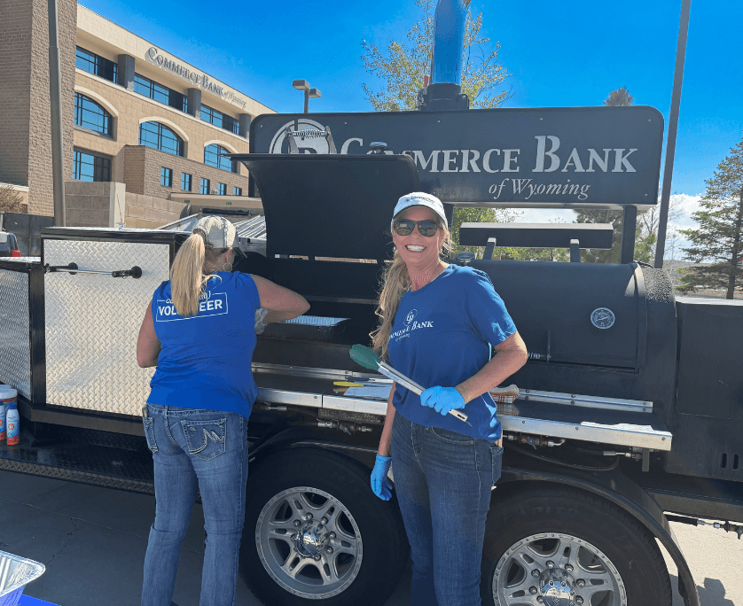 commerce bank of wyoming employees in front of a bbq smoker